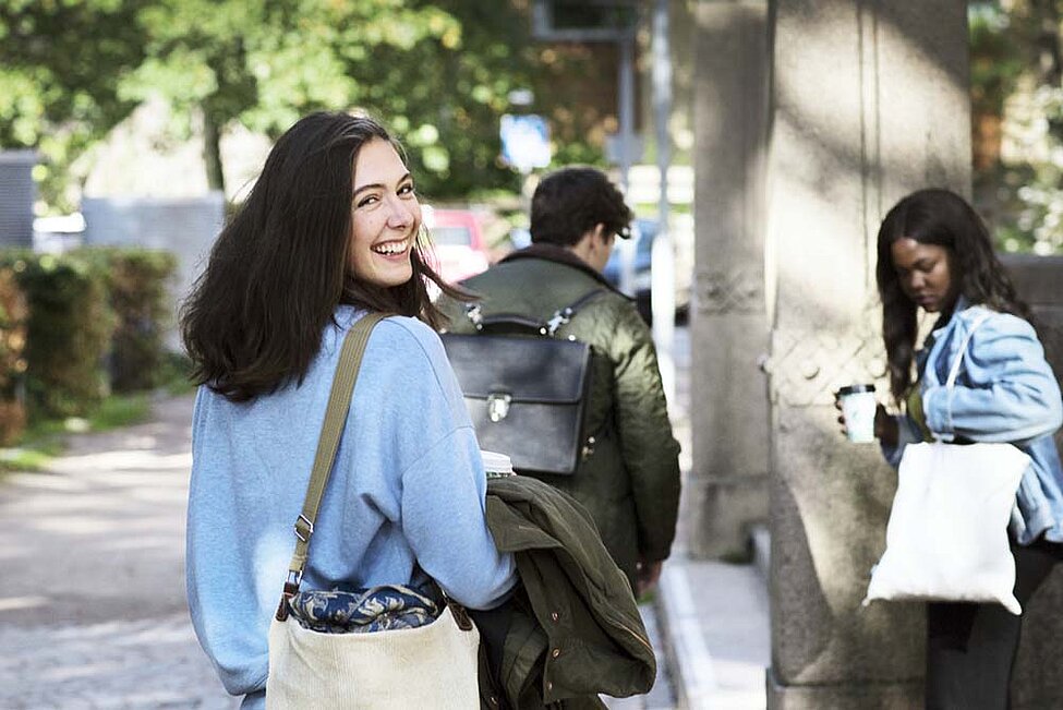 Tre studenter. Två är kvinnor med långt, mörkt hår. En är en man med kort mörkt hår.